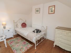A bedroom with a bed, lamp, and dresser at 1 Albion Place, Whitby