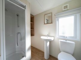 A bathroom with a shower, sink, and toilet at Tide’s Reach - Hayling Island
