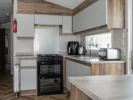 A kitchen with an oven and sink at Wavecrest - Hayling Island