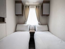 A bedroom with two single beds and a window at Wavecrest - Hayling Island