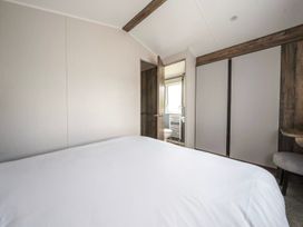 A bedroom with a bed and a bathroom visible at Wavecrest - Hayling Island