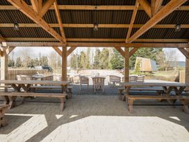 An outdoor seating area with wooden tables and benches at The Splash Pad - Billing Aquadrome
