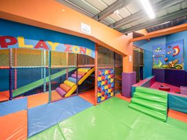 An indoor play area with play structures and colorful mats at Waterslide Way - Billing Aquadrome