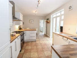 A kitchen with white cabinets wooden countertops tiled floor and dining table at 34 North Denes Road in Great Yarmouth