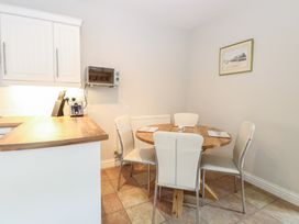 A kitchen area with wooden countertop a toaster knife block round wooden dining table four chairs and a framed picture on the wall at 34 North Denes Road in Great Yarmouth