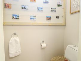 A bathroom with a toilet towel ring with a white towel and postcards on a string on the wall at 34 North Denes Road Great Yarmouth