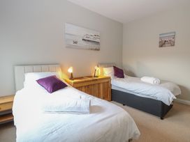 A bedroom with two single beds with white bedding and purple pillows at 34 North Denes Road in Great Yarmouth