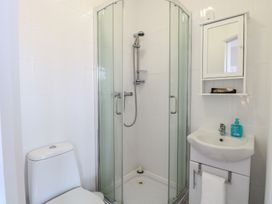 A bathroom with a toilet shower cubicle sink and mirror cabinet at 34 North Denes Road in Great Yarmouth