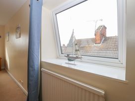 A hallway with a blue curtain a radiator and a model sailboat on the windowsill at 34 North Denes Road Great Yarmouth