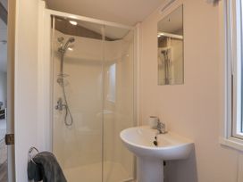 A bathroom with a shower enclosure, sink with faucet, mirror, towel on a ring, and window at Dunskey Way Portpatrick