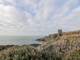 A coastal landscape with cliffs and a ruined stone building near the sea at Dunskey Way in Portpatrick