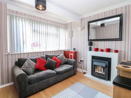 A living room with a gray sofa with red and gray cushions a fireplace with red candles and a large mirror at 271 California Sands Estate California Norfolk