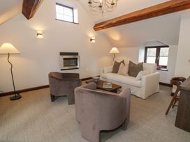 A living room with two chairs a sofa a coffee table and a fireplace at Y Granar in Conwy
