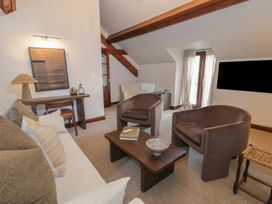 A sitting room with armchairs sofa coffee table and desk with a lamp at Y Granar in Conwy