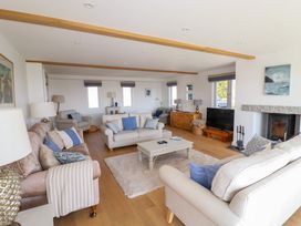A living room with sofas cushions coffee table television and fireplace at The Old Harbour Masters House in Fowey