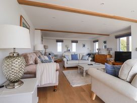 A living room with sofas a coffee table lamps and a television at The Old Harbour Masters House in Fowey