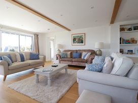 A living room with three sofas and a coffee table on a rug at The Old Harbour Masters House in Fowey