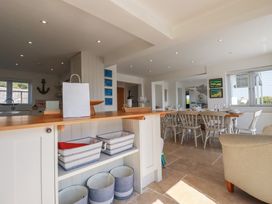 A kitchen with countertop baskets and a dining area with table and chairs at The Old Harbour Masters House in Fowey