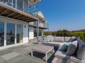 An outdoor patio with a sectional sofa cushions and a coffee table at The Old Harbour Masters House in Fowey