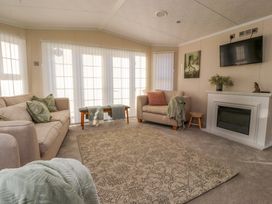 A living room with sofas a bench and a fireplace at 2 Willow Way near Lytham