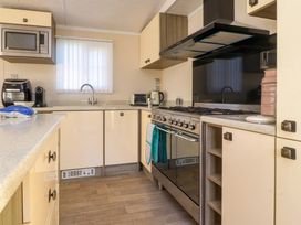 A kitchen with appliances including a microwave oven coffee maker toaster and stove at 2 Willow Way near Lytham
