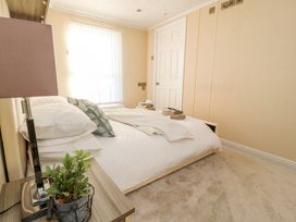 A bedroom with a bed pillows folded towels lamp and a small plant on a bedside table at 2 Willow Way near Lytham