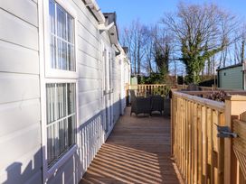 A wooden deck with patio furniture and a white house exterior near Lytham