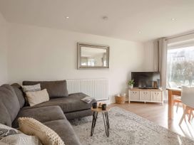 A living room with a sofa and TV at Ty Golau in Llanbedrog