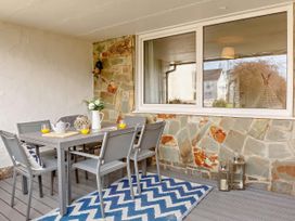A dining area with a table and chairs at Ty Golau in Llanbedrog