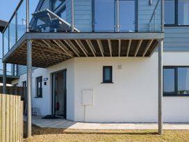 An outdoor area with a balcony, door and windows at Jacana in Perranporth