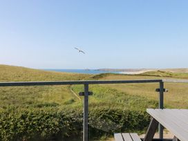 An outdoor view of the sea and hills from a balcony at Jacana in Perranporth