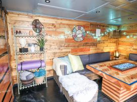A wooden room with a wicker sectional sofa and a wooden coffee table with stones at Orchard Retreat Staycation in Kirton