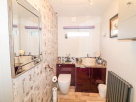 A bathroom with a toilet a countertop sink a mirror and a wall radiator at Orchard Retreat Staycation in Kirton