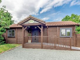 The exterior of a wooden house with a tiled roof a gravel driveway and a ramp at Orchard Retreat Staycation Kirton