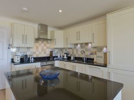 A kitchen featuring cabinets, sink, stove, toaster, and kettle at Apartment 12, Burgh Island Causeway, Bigbury-On-Sea