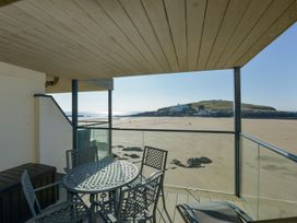 A balcony with a table and chairs overlooking the beach at Apartment 12, Burgh Island Causeway Bigbury-On-Sea