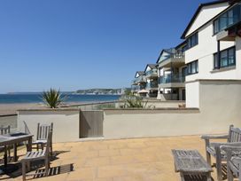 An outdoor area with a table and chairs overlooking the sea at Apartment 12, Burgh Island Causeway in Bigbury-On-Sea