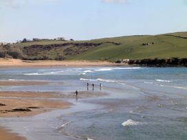 A beach with people walking along the shore at Apartment 12, Burgh Island Causeway Bigbury-On-Sea