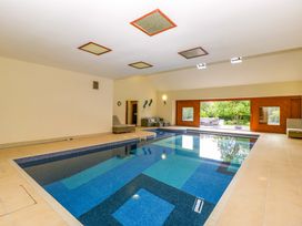 An indoor swimming pool with large windows and seating at Heathcliffe House, Castleton near Cardiff