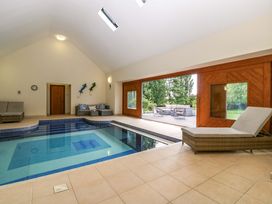 An indoor pool area with a sofa and large windows at Heathcliffe House Caslteton near Cardiff