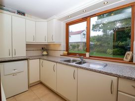 A kitchen with cabinets, sink, and window at Heathcliffe House in Castleton near Cardiff