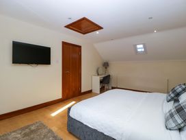 A bedroom with a bed and a television at Heathcliffe House in Castleton near Cardiff