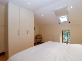 A bedroom featuring a wardrobe, bed, chair, and window at Heathcliffe House Castleton near Cardiff