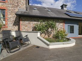 An outdoor area with lounge chairs and a flower bed at Heathcliffe House in Castleton near Cardiff