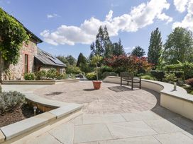 A garden with a circular patio and a bench at Heathcliffe House, Castleton near Cardiff