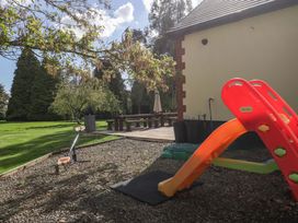 A garden with a slide and scooter at Heathcliffe House Castleton near Cardiff