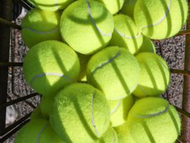A collection of tennis balls stacked on a metal rack at Heathcliffe House in Castleton near Cardiff