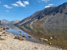 A lake with mountains in the background and a rocky shore at Flat 6 Aikbank in Whitehaven