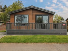 A cabin with large windows and a deck at Peony in Eardisland
