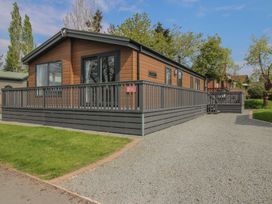 A house with a deck and grass area at Peony in Eardisland